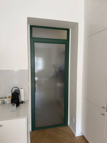 Dveře v zeleném rámu s matným sklem a nadsvětlíkem